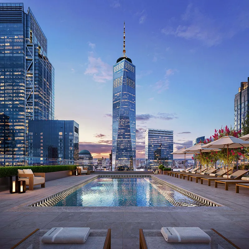 Rooftop pool with One World Trade Center and Financial District skyline at dusk